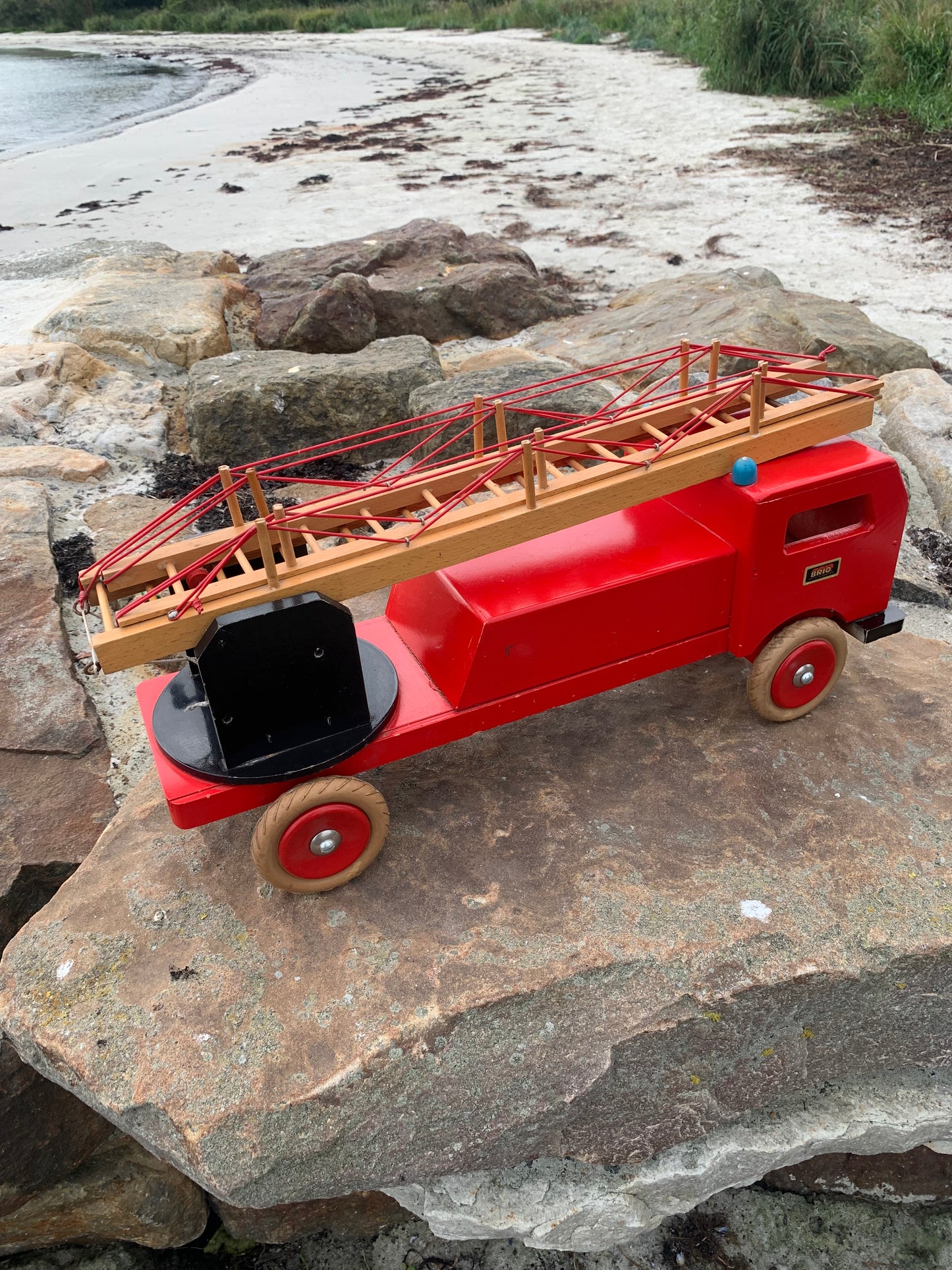 Vacker och stor gammal röd BRIO brandbil med stege