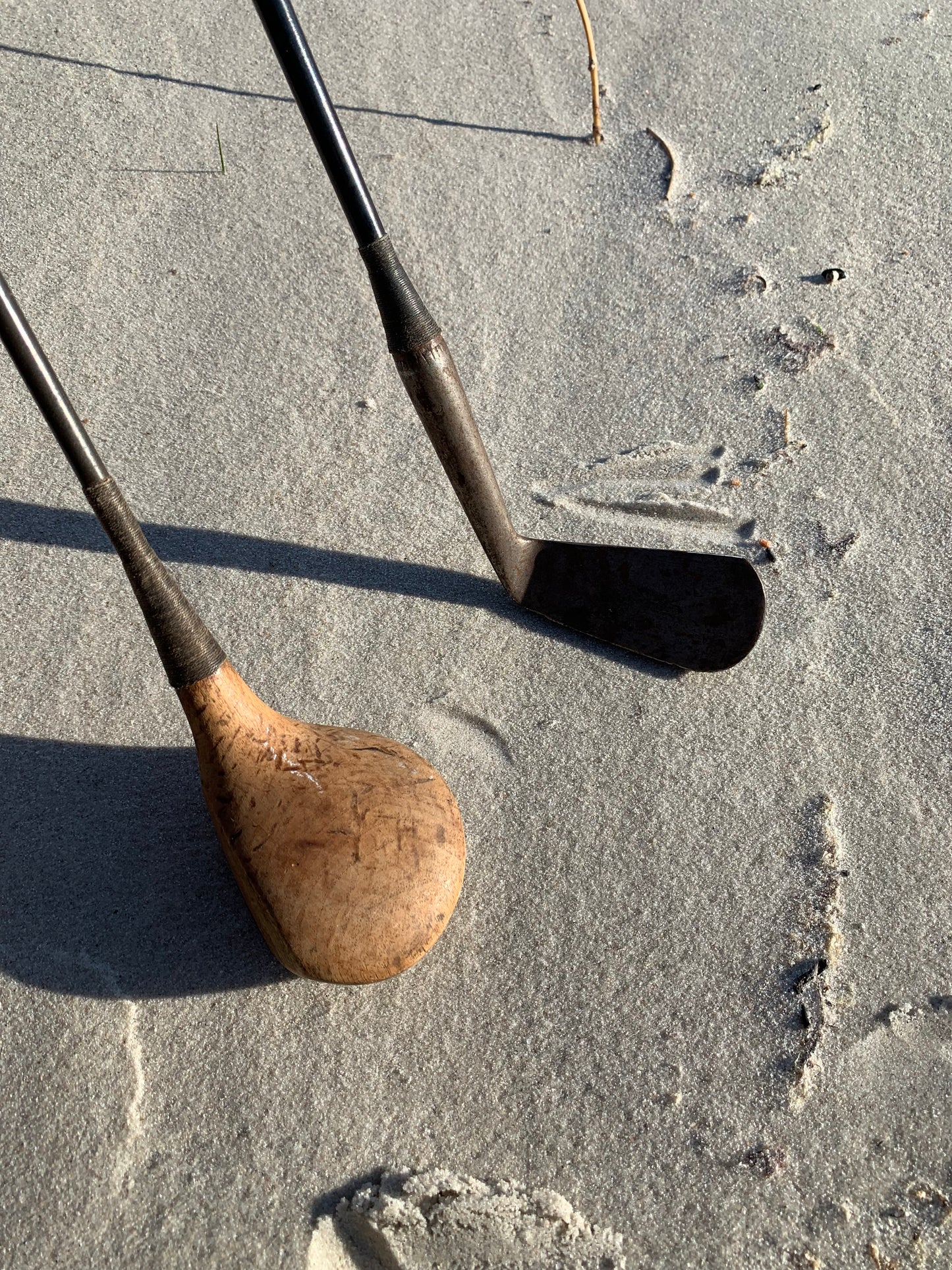 Gammal golfväska i skinn med två gamla klubbor